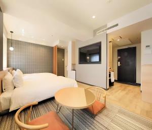 a bedroom with a bed and a table and a tv at Richmond Hotel Matsumoto in Matsumoto