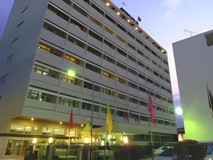 a large building with flags in front of it at Ubon Hotel in Ubon Ratchathani