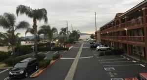 an empty street with cars parked in a parking lot at Grand Park Inn in Baldwin Park