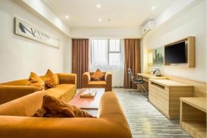 a living room with two couches and a television at City Comfort Inn Zhaoqing Qixingyan Scenic Area Xinghu Archway in Zhaoqing