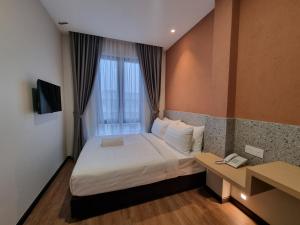 una habitación de hotel con una cama y una ventana en Miico Hotel Permas Jaya, en Johor Bahru 124 fotos más