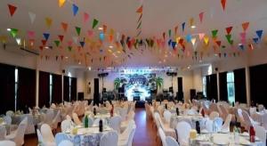 a banquet hall with white tables and chairs and flags at Bacchus Home Resort in Pran Buri +185 photos