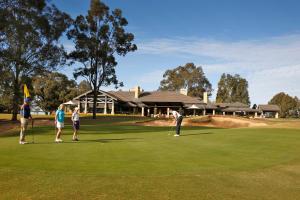 a group of people playing golf on a golf course at Chateau Elan At The Vintage in Pokolbin