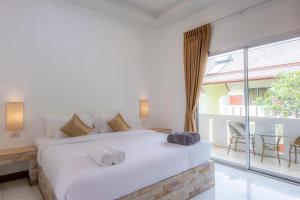 a bedroom with a large bed and a balcony at Sunrise Serenity Phuket Resort in Karon Beach +75 photos
