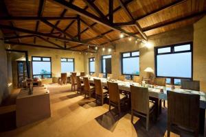 a large dining room with a long table and chairs at Hananoie - A Permaculture Resort in Astam