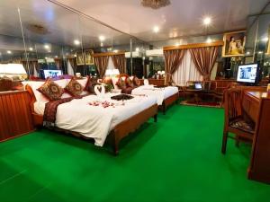 two beds in a room with green carpet at Asia Hotel in Phnom Penh