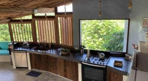 a kitchen with two sinks and a large window at BambooJam Villa in La Ceiba +58 photos
