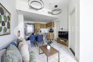 ein Wohnzimmer mit einem blauen Sofa und einem Tisch in der Unterkunft Bloomfields Serenity 1br Al Maryah Island in Abu Dhabi