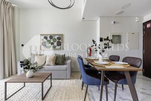 ein Wohnzimmer mit Tisch und Couch in der Unterkunft Bloomfields Serenity 1br Al Maryah Island in Abu Dhabi + 9 Fotos