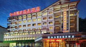 ein Gebäude mit einem Schild an der Seite in der Unterkunft Zhangjiajie Xiangfu International Hot Springs Hotel in Zhangjiajie