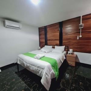 a bedroom with a large bed with a wooden headboard at Menoreh Farm Stay Samigaluh Kulonprogo in Kalirejo