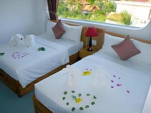 two beds in a room with hearts on the sheets at Damina boutique hotel in Mui Ne +56 photos