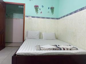 - un lit avec des draps et des oreillers blancs dans l'établissement Cường Phú Hotel Hồ Chí Minh, à Hô-Chi-Minh-Ville 5 autres photos