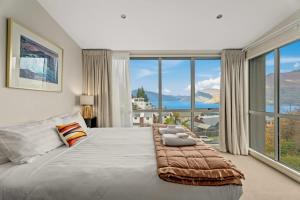ein Schlafzimmer mit einem großen Bett mit einem großen Fenster in der Unterkunft Vancouver Spa Views in Queenstown