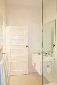 a white bathroom with a sink and a shower at Mollisons in Kyneton