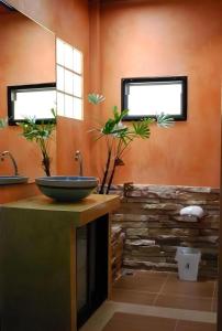 ein Badezimmer mit einem Waschbecken und einer Steinmauer in der Unterkunft Tanisa Resort in Na Dhung