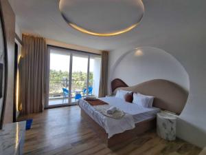a bedroom with a large bed and a large window at Palette The Moon Hotel Goa in Nerul