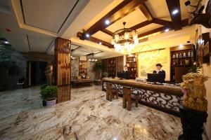 two people sitting at a bar in a restaurant at Yazhu Creekfront Boutique Hotel in Zhangjiajie