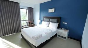 a blue bedroom with a bed and a blue wall at Sixty-Sixplace in Ban Khok Lo
