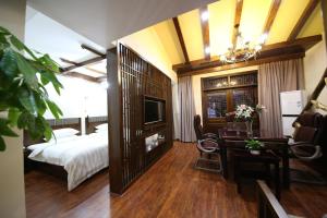 a hotel room with a bed and a desk and a bedroom at Yazhu Creekfront Boutique Hotel in Zhangjiajie