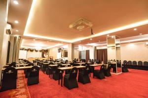 a banquet hall with tables and chairs in a room at Grand Darmo Suite by AMITHYA in Surabaya