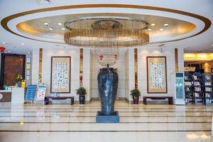 eine große Lobby mit einem großen Kronleuchter in einem Gebäude in der Unterkunft Kunming Wenhui Hotel in Kunming