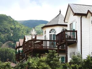 une grande maison avec une terrasse sur le côté dans l'établissement Daegwalnyeong Sky Keeper Pension, à Pyeongchang