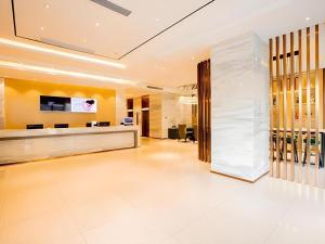 an office lobby with a reception desk and a wall of wine bottles at City Comfort Inn Nanning Railway Station in Nanning