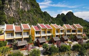 eine Reihe von Gebäuden vor einem Berg in der Unterkunft Doan Gia Resort in Cừ Lạc