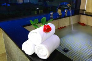 a stack of towels with a rose on top of a sink at Artisan Hostel in Toucheng