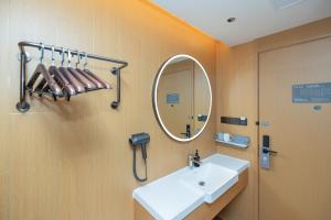 un baño con lavabo y espejo en JI Hotel Shanghai Daning Yichuan Road, en Shanghái 14 fotos más