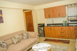 a living room with a couch and a kitchen at Carlton Stays in Nanyuki +17 photos
