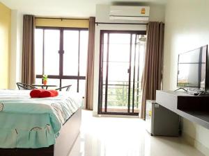 a bedroom with a bed and a tv andwindows at THE ALL 24 Luxury Residence in Bangkok +98 photos