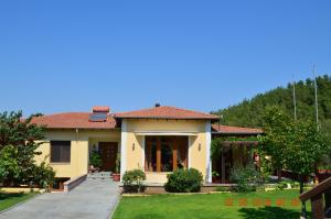 Kavala Villa في Amisianá: منزل اصفر بسقف احمر