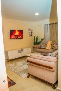 a living room with two couches and a fireplace at Carlton Stays in Nanyuki