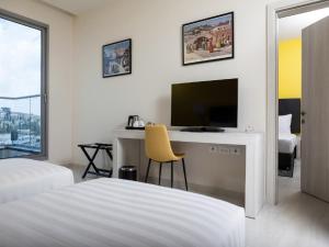 Televiisor ja/või meelelahutuskeskus majutusasutuses Legacy Hotel ַ& Convention Center Nazareth
