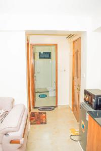 a living room with a couch and a bathroom at Carlton Stays in Nanyuki