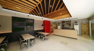 a restaurant with tables and chairs and a kitchen at Majestic Hotel Manila - Formerly Octagon Mansion Hotel Manila in Manila