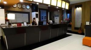 a woman sitting at a counter in a store at Majestic Hotel Manila - Formerly Octagon Mansion Hotel Manila in Manila