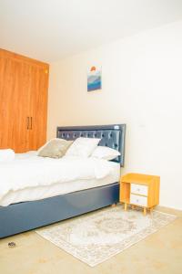 a bedroom with a large bed and a wooden cabinet at Carlton Stays in Nanyuki