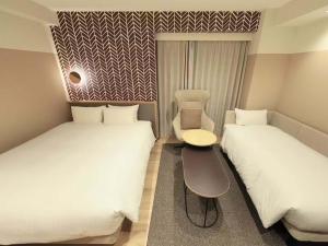 a room with two beds and a chair between them at Richmond Hotel Matsumoto in Matsumoto +44 photos