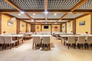 a dining room with white tables and chairs at JinJiang Inn Baoji Administra Tion Center in Baoji