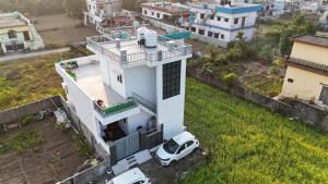 an aerial view of a white house with a white car at Panwar peaceful homestay in Jhājra