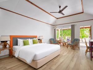a bedroom with a white bed and a dining room at Villa Park Sun Island Resort in Maamigili
