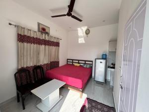 a small room with a red bed and a kitchen at Panwar peaceful homestay in Jhājra +14 photos