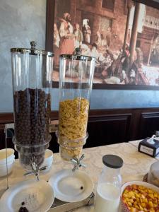 a table with two glass vases filled with food at Shams Alweibdeh Hotel in Amman