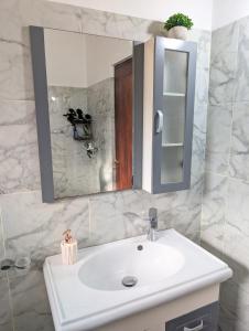 une salle de bains avec un lavabo blanc et un miroir dans l'établissement Home in Colombo 06 - Minutes from Everywhere, à Kirillapone