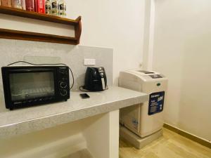 Un microondas sobre un mostrador junto a una impresora. en ML villa, en Ahangama