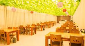 ein Esszimmer mit Tischen, Stühlen und Lichtern in der Unterkunft GreenTree Inn Fuyang Yijing International North Business in Fuyang