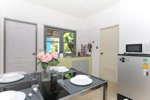 Sisters Ari 2-bedrooms house, Bang Tao beach في Ban Thalat Choeng Thale: مطبخ مع طاولة مع إناء من الزهور +12 صورة
